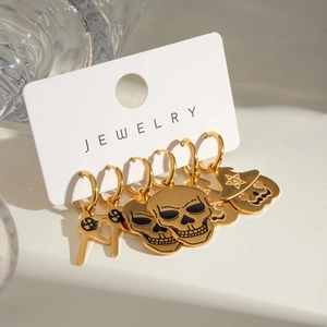 Detail of gold Halloween earring set with skull and ghost charms on display card
