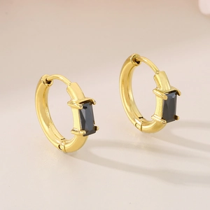 Vue détaillée des boucles d'oreilles créoles dorées avec pierre noire rectangulaire
