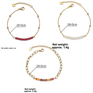 Detail view of gold stainless steel bracelets with red, white pearls and colored beads