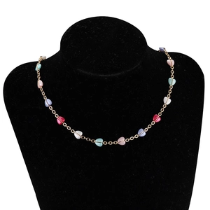 Golden heart-shaped bead chain necklace with colorful pendants on black bust display