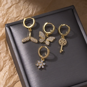 Pendentifs papillon et queue de poisson dorés avec zircons sur une boîte à bijoux sombre
