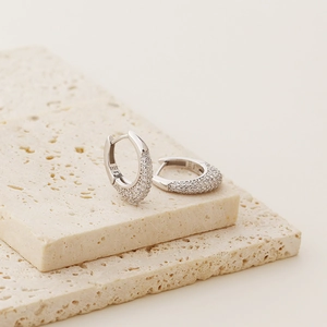 Macro shot of S925 sterling silver stamp and pave diamond details on U-shaped earrings