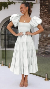 Detail of white puff sleeve midi dress featuring tiered cake skirt and ruched square neckline