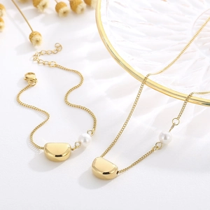 Détail de la parure de bijoux avec pendentif lune dorée et perle avec bracelet assorti