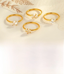 Close-up of four gold C-shaped nose rings with clear zircon stone settings in 0.8mm size
