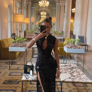 Detail of elegant black lace dress featuring a chic U-neck and sexy high side slit design