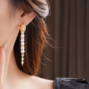 Elegant gold drop earrings with white pearls and sparkling marquise zircons detail