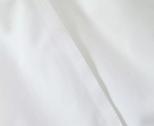 Close-up of durable white textile texture and neat stitching on cargo pants pocket