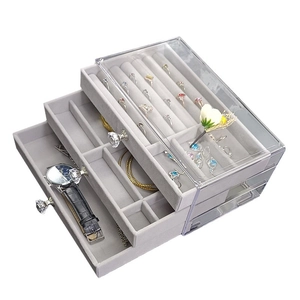 Three-layer acrylic jewelry box with grey velvet drawers and ring slots seen from 45-degree angle