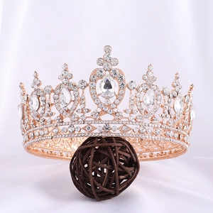 Close-up of rose gold bridal crown with crystal drops on a textured background