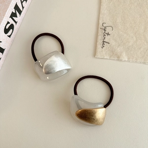 Detail shot of minimalist hair ties with gold and silver textured metallic resin charms