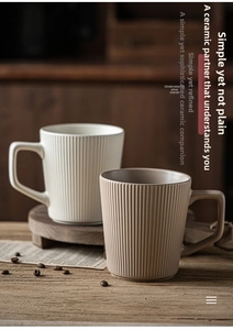 Detail view of retro fluted ceramic mugs in cream and taupe on a wooden tray