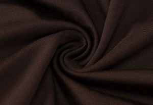 Macro shot of brown ribbed knit fabric detail showing elegant spiral texture and drape