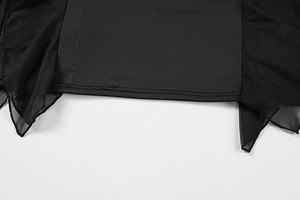 Dettaglio di abito in maglia nera con bordo asimmetrico in mesh e cuciture rifinite