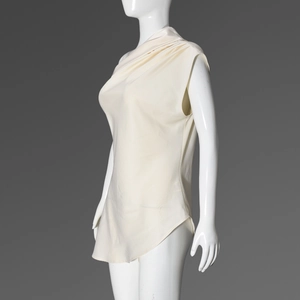Detail of elegant off-white satin top showing asymmetric draped neck and smooth silk-like texture