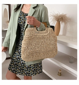 Detail of hand-woven straw tote bag with round wooden handles for summer vacation fashion
