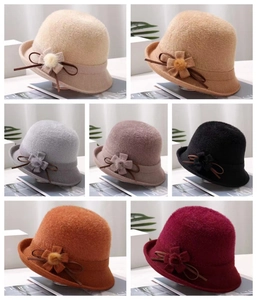 Detail of elegant winter knitted cloche hats with decorative fur balls in multiple colors