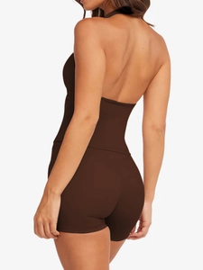 Detail view of deep brown halter neck yoga bodysuit with open back design and slim fit shorts