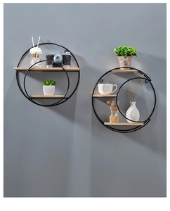 Detail of round wall shelves with black metal frames and natural wood tiers on grey wall