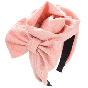 Pink waffle fabric headband with oversized 3D flower and bow on a clean white background