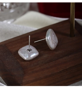 Macro shot of square baroque freshwater pearls with S925 silver needles on a wood stand