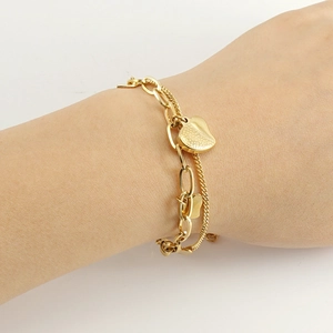 Double-layered 18k gold plated stainless steel bracelet with a heart charm on model