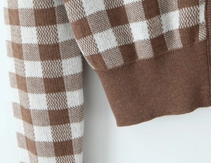 Detailed macro view of checkered knit cardigan sleeve texture and ribbed cuff stitching