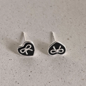 S925 sterling silver black heart stud earrings with silver bow design on grey background