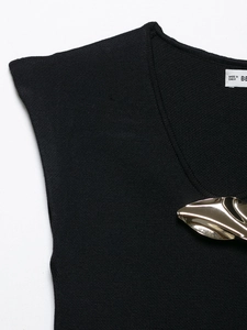 Detailed view of black knitted tank top featuring a signature gold metal leaf embellishment