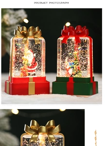 Close-up of decorative red bow on a Christmas snow globe lantern with warm LED light