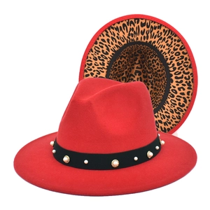 Detail of red fedora hat featuring a black band with pearls and leopard print lining