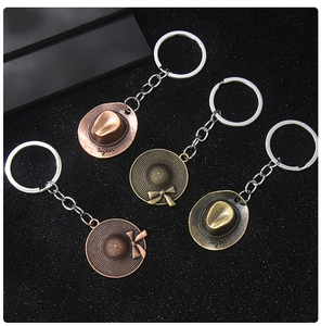 Macro shot of metal cowboy hat pendants and bow hat keychains in four vintage metallic tones