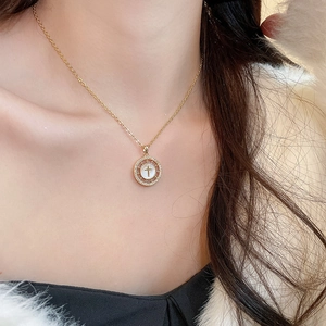 Gros plan détaillé du collier croix plaqué or 18 carats avec zircons et nacre élégante