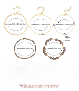 Detail of five-piece gold alloy anklet set featuring turquoise beads and evil eye charms