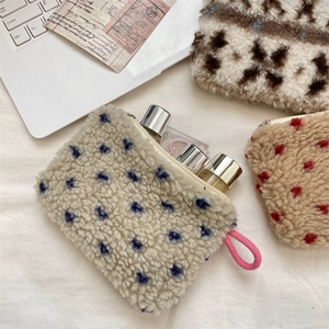 Close-up of plush fleece storage bag with polka dot pattern and pink braided handle
