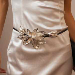 Détail de la boucle fleur tulipe métallique sur une fine ceinture noire pour femme