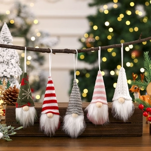 Five knit Christmas gnomes hanging on a wood branch with festive bokeh background