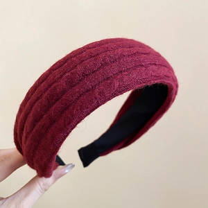 Détail montrant la texture tricotée bordeaux du bandeau élégant à larges bords