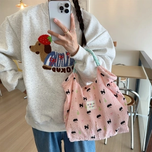 Pink bubble fabric handbag with black cat print shown in a casual lifestyle mirror selfie