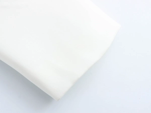 Macro shot of white high-density fabric texture and folded material on blazer