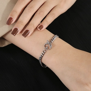Détail du bracelet chaîne gourmette en titane argenté avec fermoir à bascule OT en cœur
