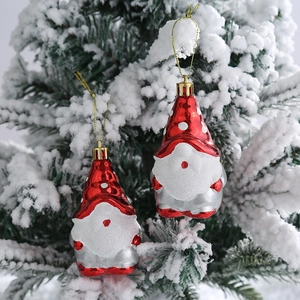Gnomos navideños rojos con lunares colgados en una rama de árbol de Navidad nevada