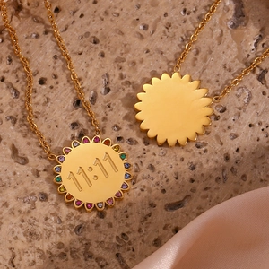 Detailed macro view of 18K gold sunburst pendant with 11:11 engraving and colorful crystals