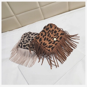 Close-up of leopard print crossbody bags with fringe tassels and magnetic snap closure