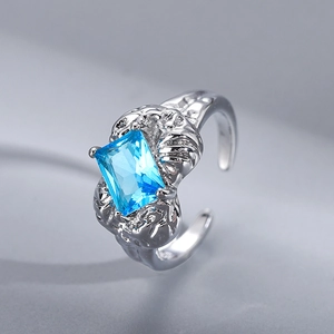 Irregular textured silver open ring with a rectangular blue gemstone and minimalist design