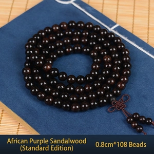 Macro detail of 108 African Blackwood prayer beads on a blue fabric background