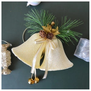 Detail of gold glitter Christmas bells with pine cones, needles and elegant golden ribbons