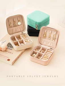 Flat lay of colorful velvet jewelry boxes in cream, pink, green and black colors