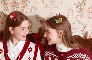 Detail of festive reindeer antler hair clips with bells and sequins on models