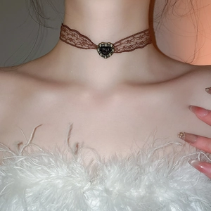 Close-up of brown lace choker featuring a black heart pendant with faux pearls